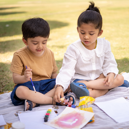 A Boy and Girl Drawing Together Outdoors on a Sunny Day